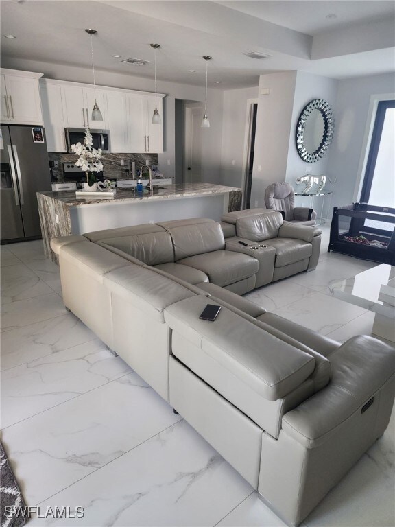 Living area featuring light marble finish floors a