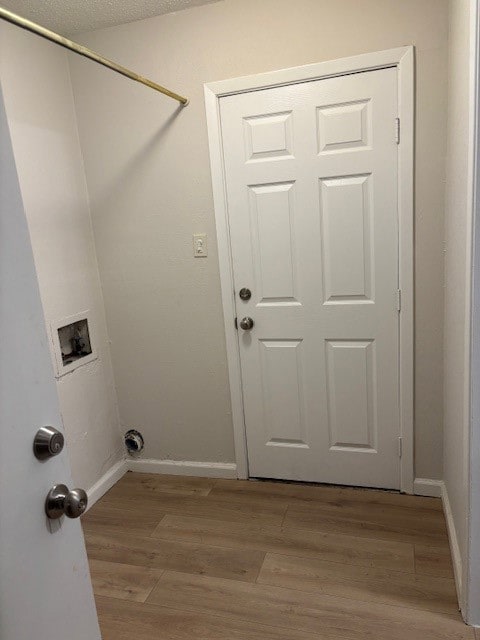 Laundry area with light wood-style floors and washer hookup