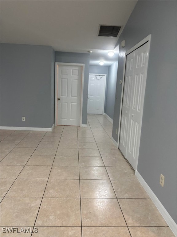 Hallway featuring light tile patterned floors and