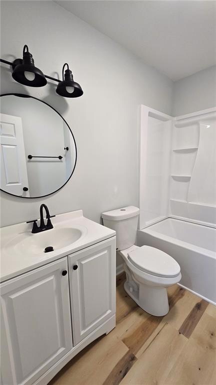 Full bathroom featuring light wood-style floors, vanity, and washtub / shower combination