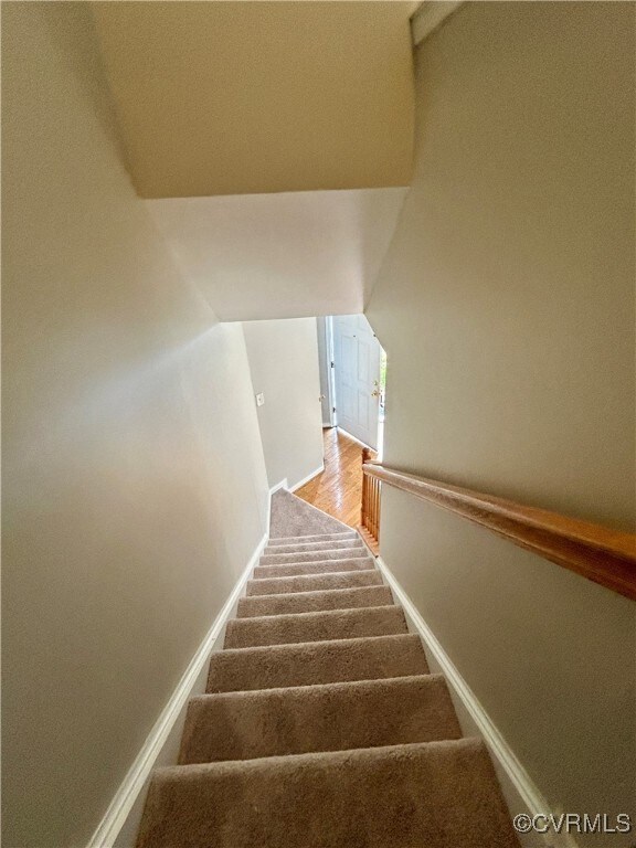 Staircase featuring hardwood / wood-style floors