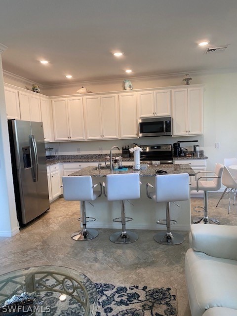 Kitchen featuring a kitchen island with sink, dark