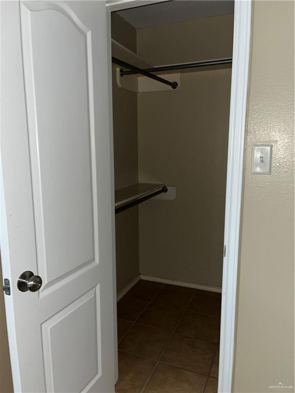 Spacious closet featuring dark tile patterned flooring