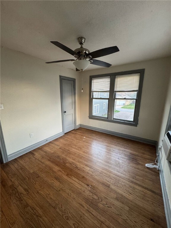 Empty room featuring ceiling fan, wood-type floori