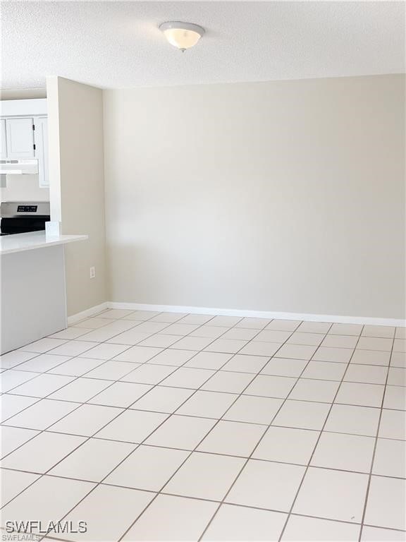 Spare room with a textured ceiling and baseboards