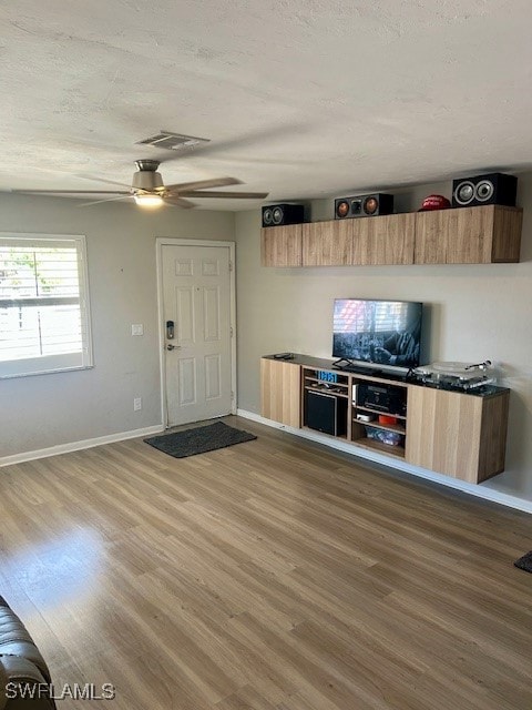 Unfurnished living room with baseboards, wood fini