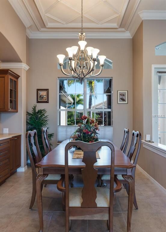 Dining room with coiffured ceiling and built-in bu