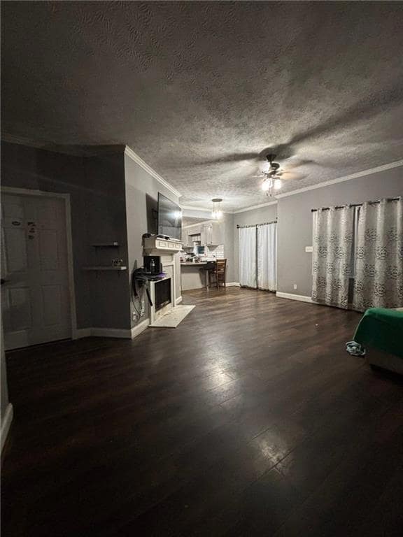 Living area featuring crown molding, dark wood-style flooring, a textured ceiling, and a ceiling fan