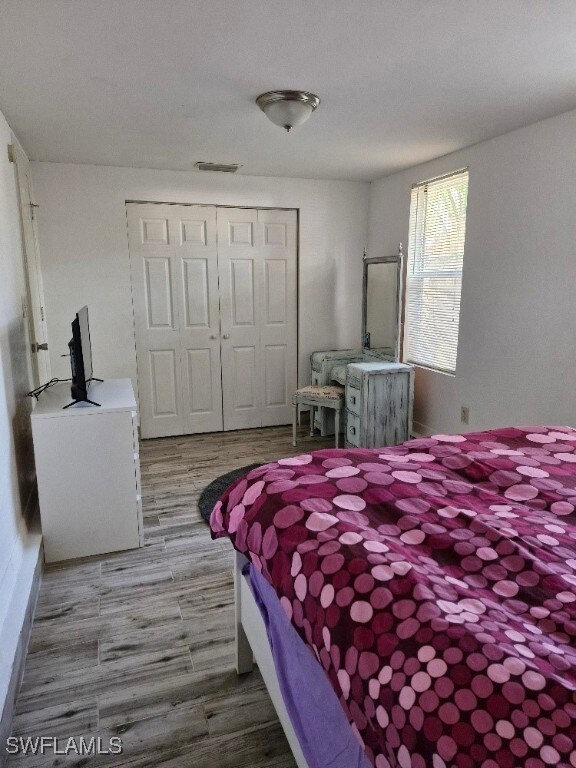Bedroom with light wood-style floors, visible vent
