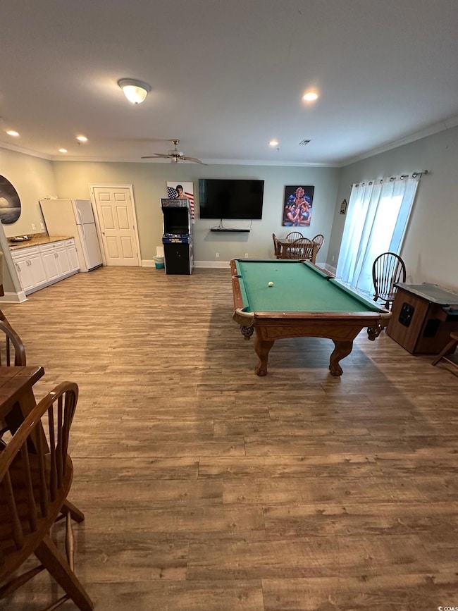 Playroom featuring hardwood / wood-style flooring, ceiling fan, ornamental molding, and billiards