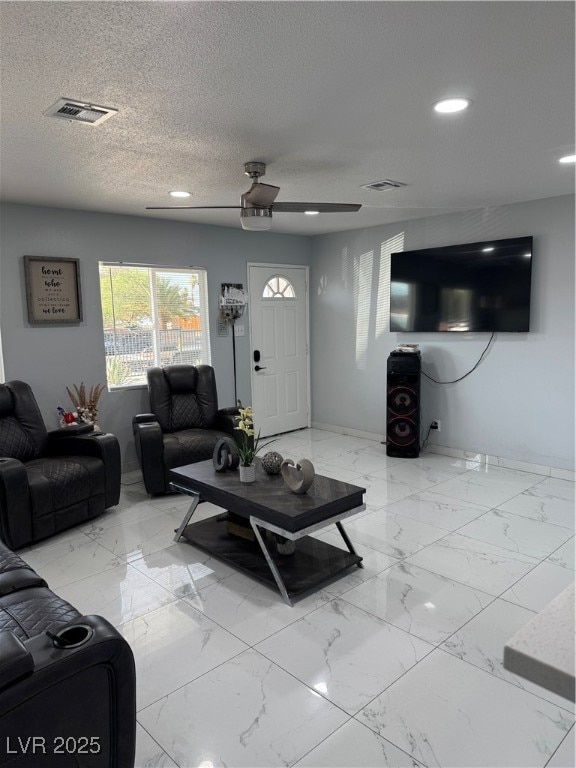 Living room featuring light marble finish flooring, a textured ceiling, ceiling fan, and recessed lighting