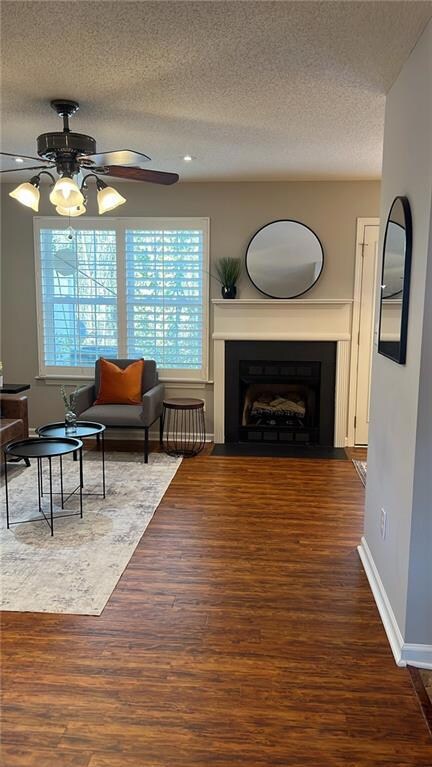 Sitting room featuring dark wood-type flooring, ce