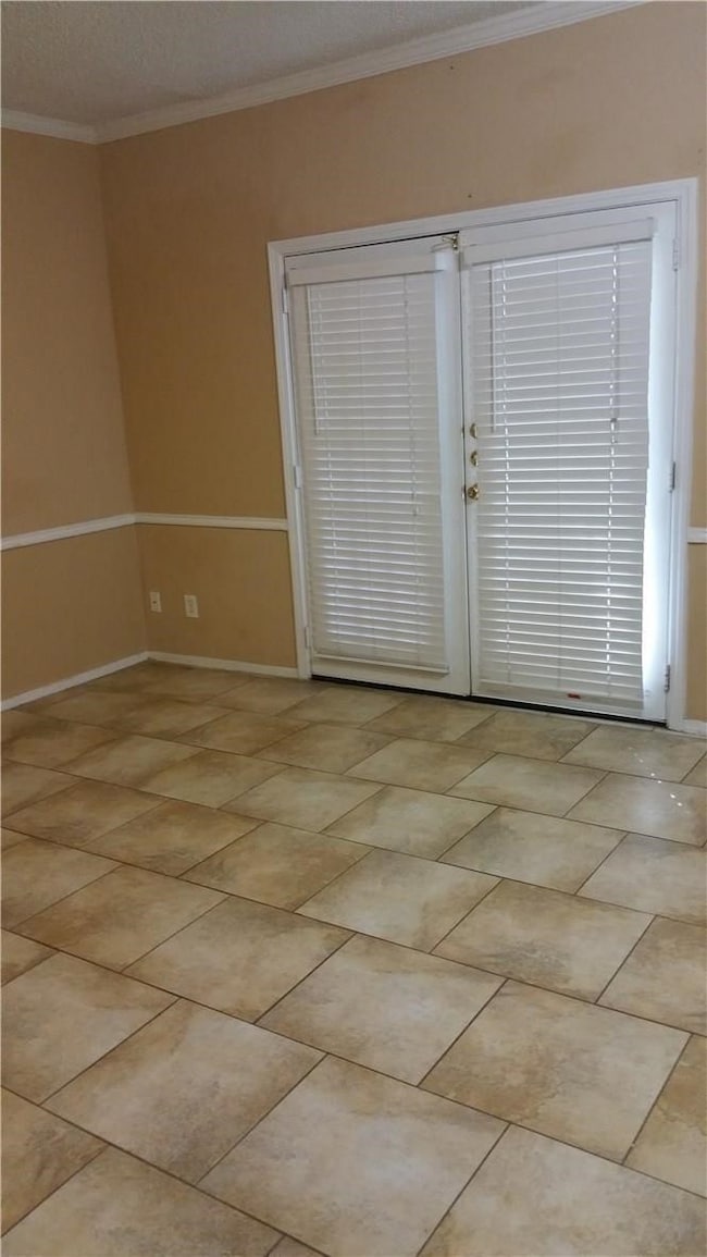 Another view of the Living Room with room Chair rail and crown molding and french doors that lead to the patio