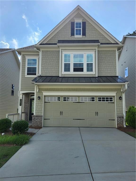 Craftsman house with a standing seam roof, concrete driveway, and a garage