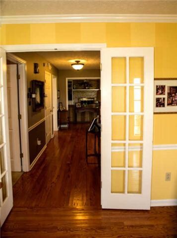 This Lovely Foyer features Beautiful Hardwood Floors and Stunning French Doors