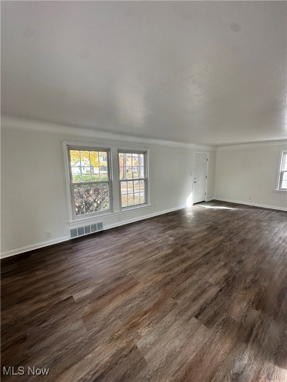 Spare room with dark wood-style floors and baseboards