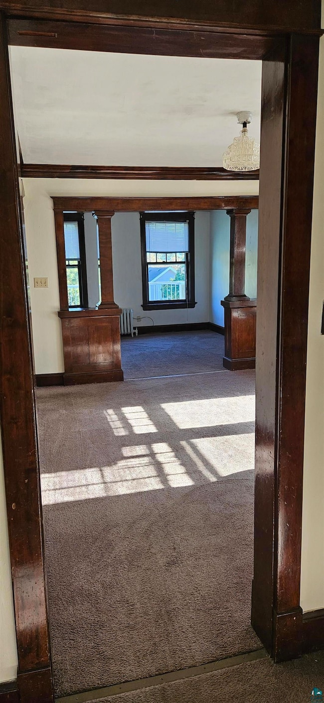 Unfurnished living room featuring carpet and radia