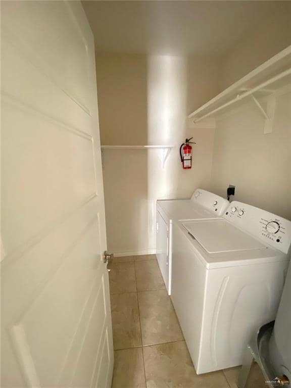 Laundry room featuring independent washer and dryer and light tile patterned flooring