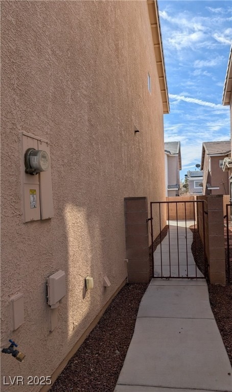 View of side of property featuring fence, a gate,