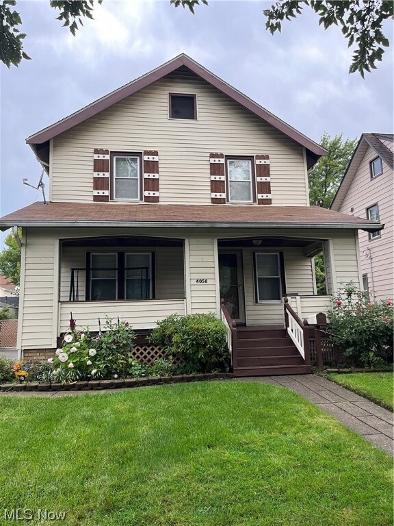 View of front of property with a porch and a front lawn