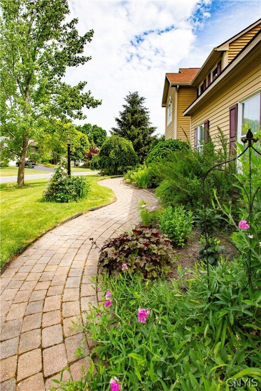 Front paver walkway with garden/mature landscaping