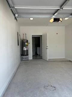 Garage featuring water heater and a garage door opener