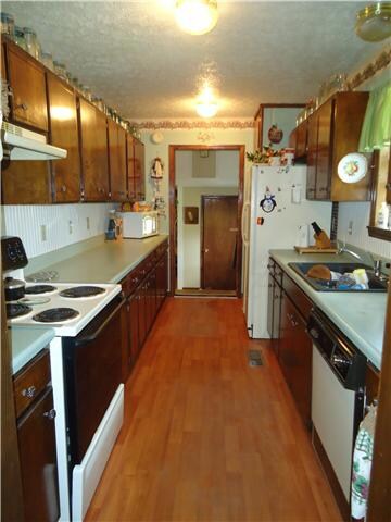 The galley kitchen has an abundance of countertop work space and cabinets. There is a window looking to the backyard and laminate flooring.