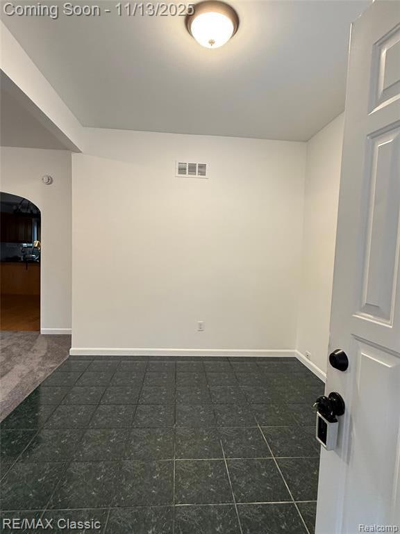 Spare room with arched walkways and baseboards