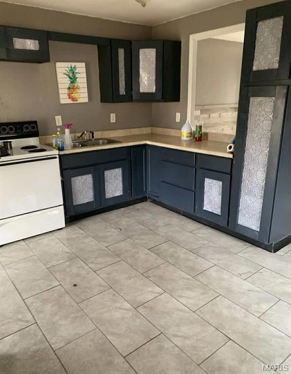 Kitchen with white electric range, exhaust hood, light countertops, and light tile patterned floors