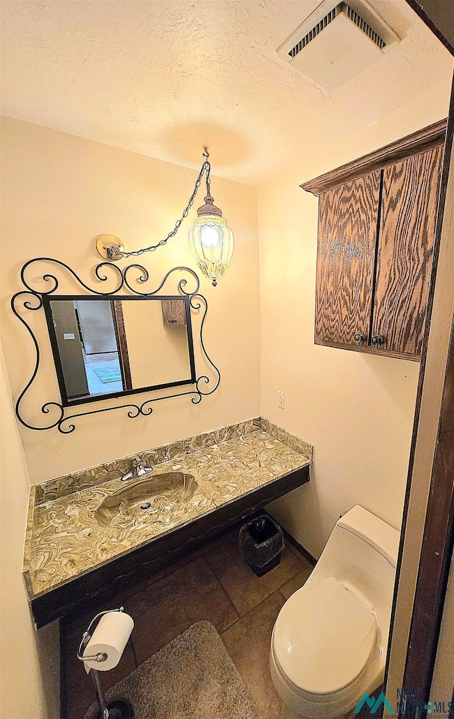 Bathroom featuring vanity, tile patterned floors, and a textured ceiling