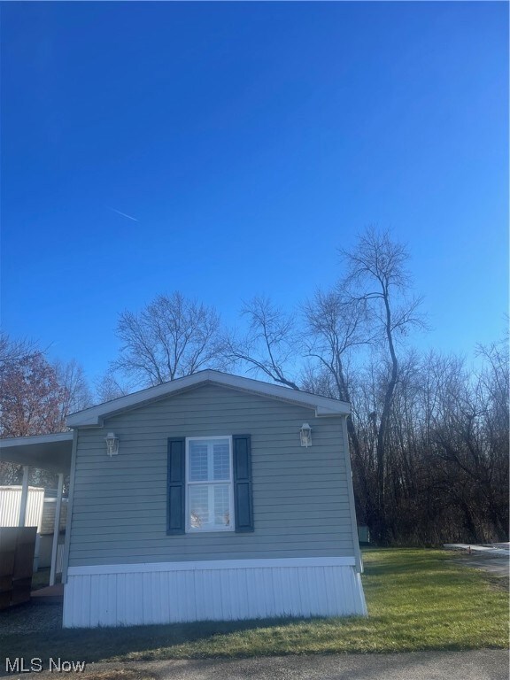 View of side of property featuring a lawn