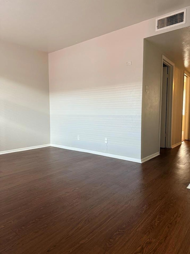 Empty room featuring dark wood finished floors an