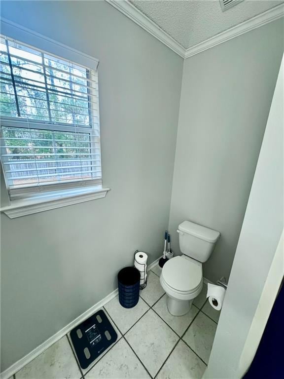 Bathroom with a textured ceiling, crown molding, and tile patterned floors