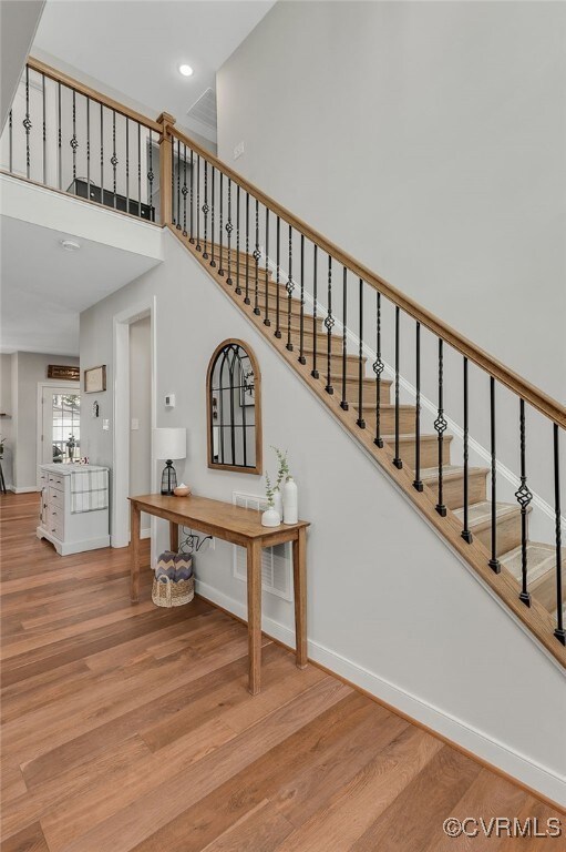 Stairway with recessed lighting, a high ceiling, b