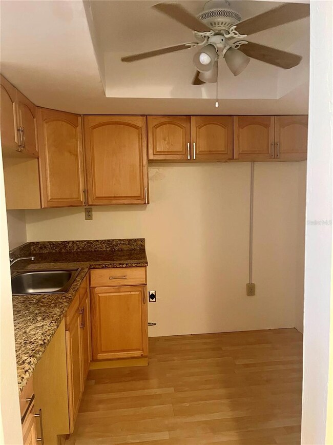 Kitchen features granite counters and wood cabinets.