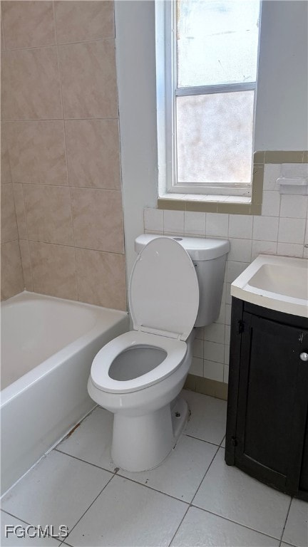Bathroom featuring vanity, light tile patterned floors, tile walls, and shower / bathtub combination