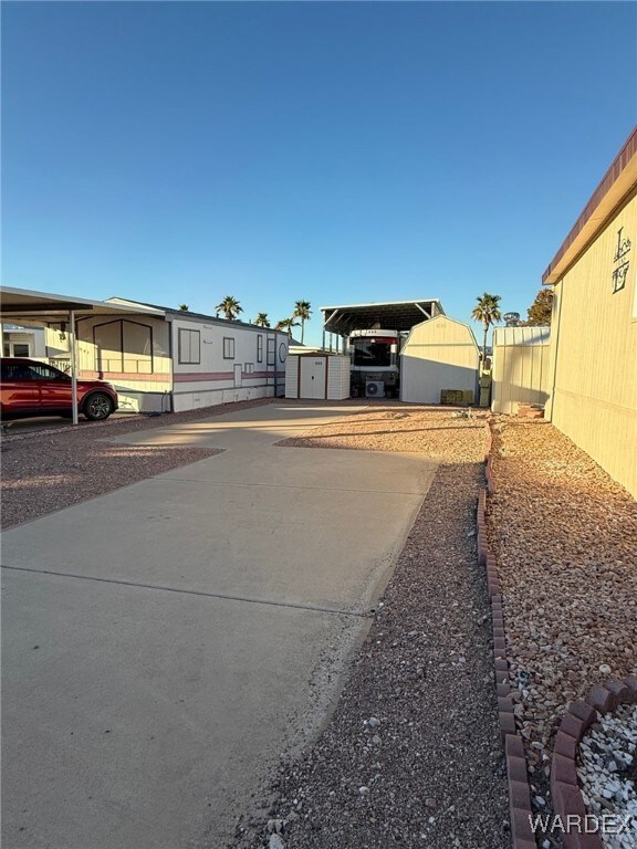 View of lot with a storage shed, a carport, and an