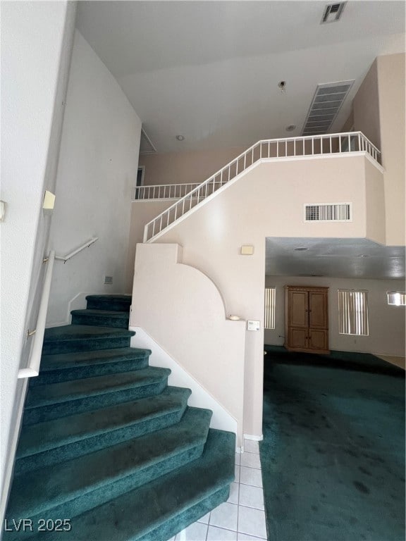 Staircase featuring carpet, tile patterned floorin