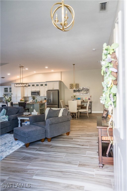 Living room featuring a notable chandelier and vau