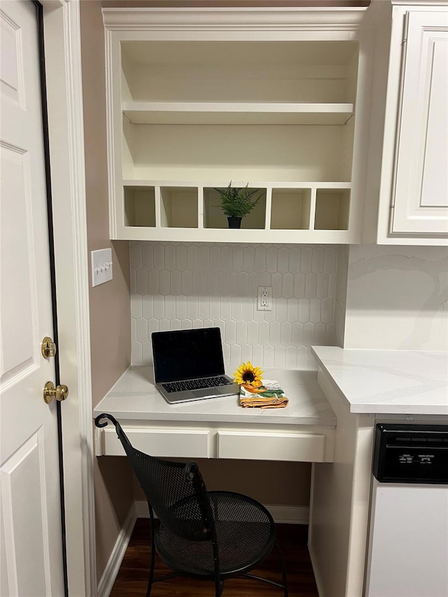 Office area featuring built in desk and wood fini