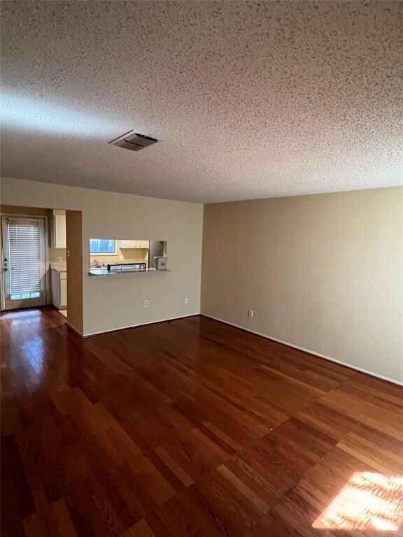 Spare room with dark wood finished floors and a t