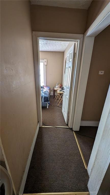 Corridor featuring dark carpet