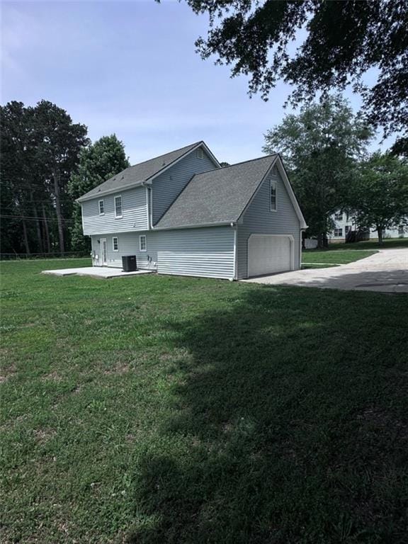 View of side of property featuring a garage, a yar