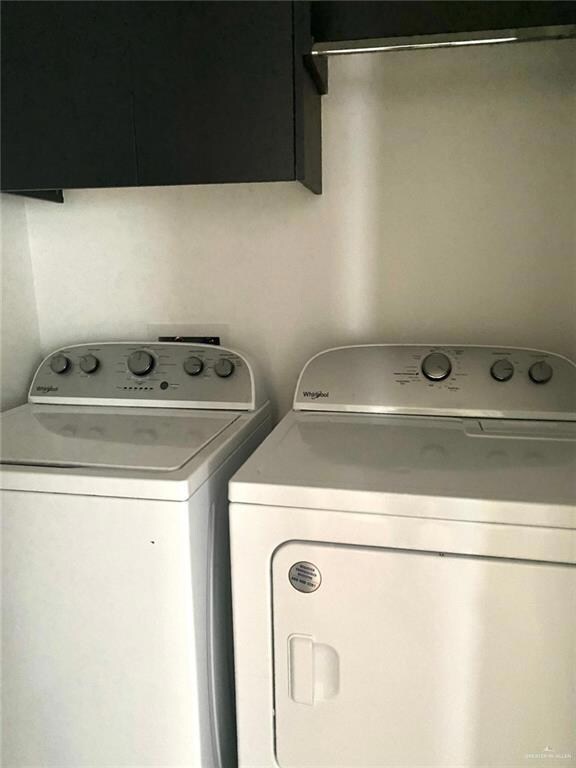 Washroom with cabinet space and washer and clothes dryer