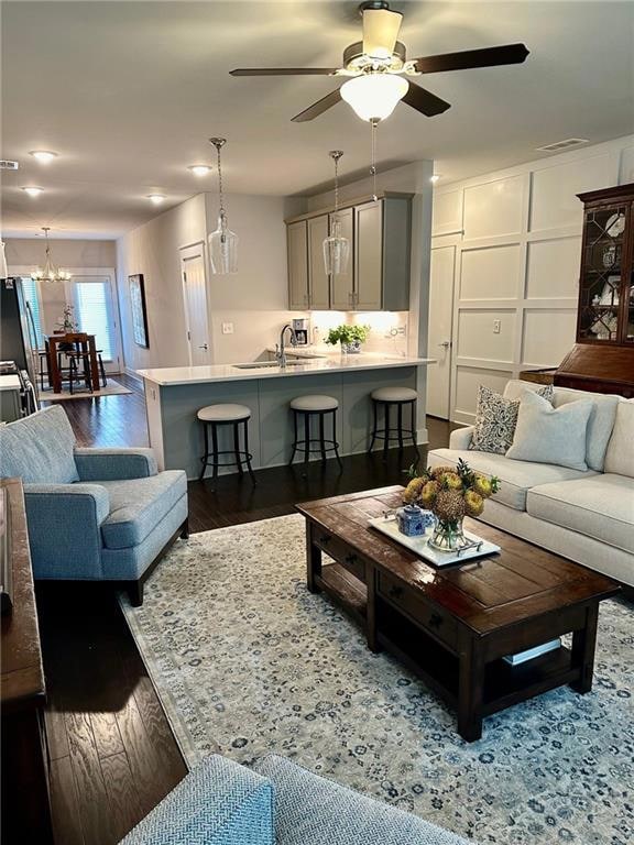 Living room with ceiling fan with notable chandeli