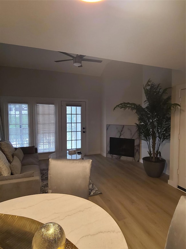 Living room with ceiling fan, a fireplace, and har