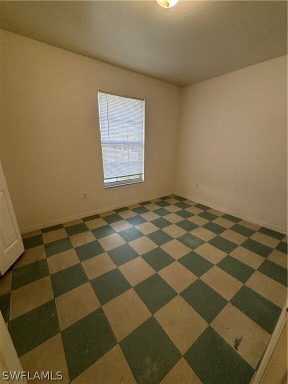 Unfurnished room with dark tile floors