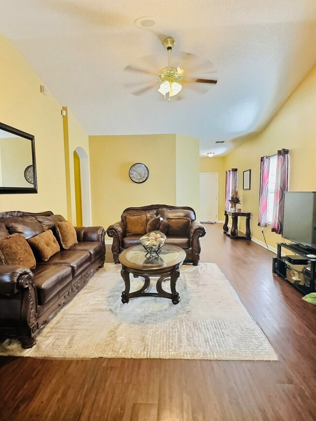 Living room with ceiling fan and hardwood / wood-s
