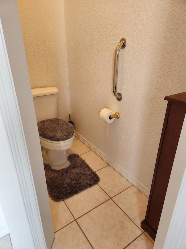 Bathroom featuring toilet and tile patterned floo