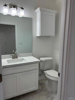 Bathroom featuring tile floors, vanity, and toilet
